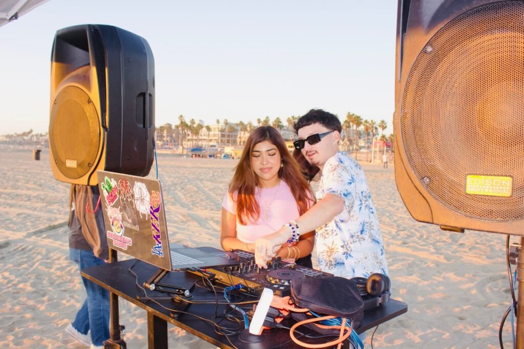 Niko and a friend behind the decks at golden hour on the beach