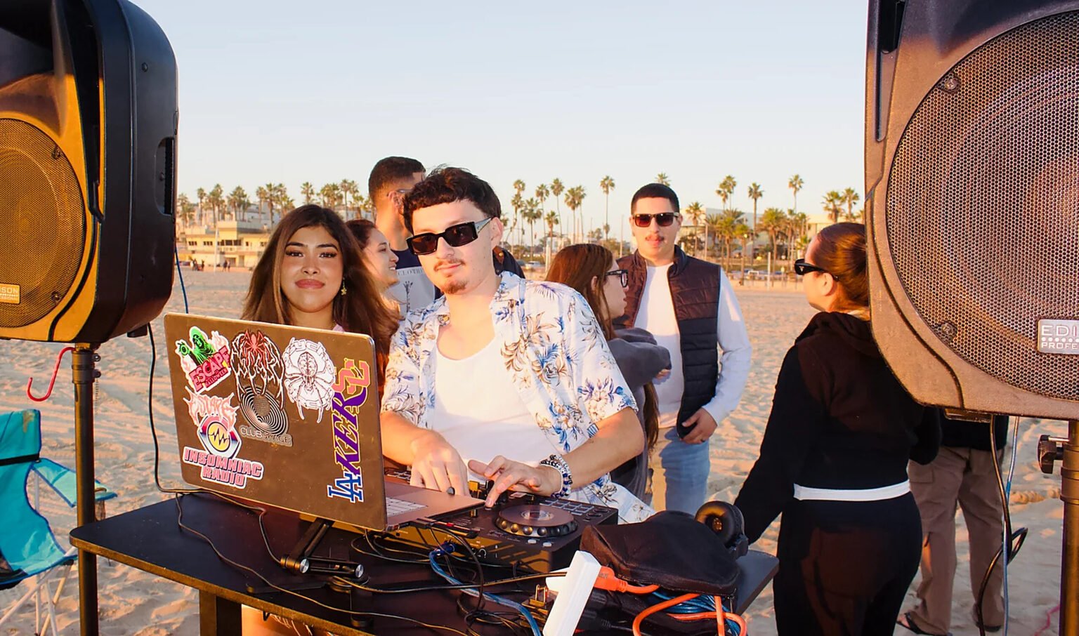 Niko DJing on the beach with a crowd gathered around